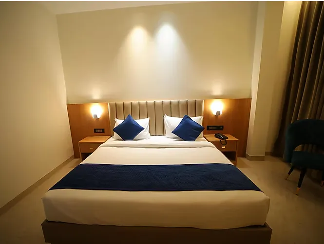 Deluxe room at The RS Casa Hotel Agra showing larger space, seating area, and window lighting