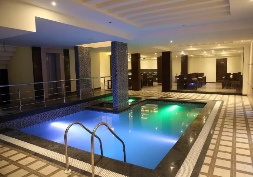 Swimming pool at The Raj Vilas Agra with surrounding deck space and leisure seating