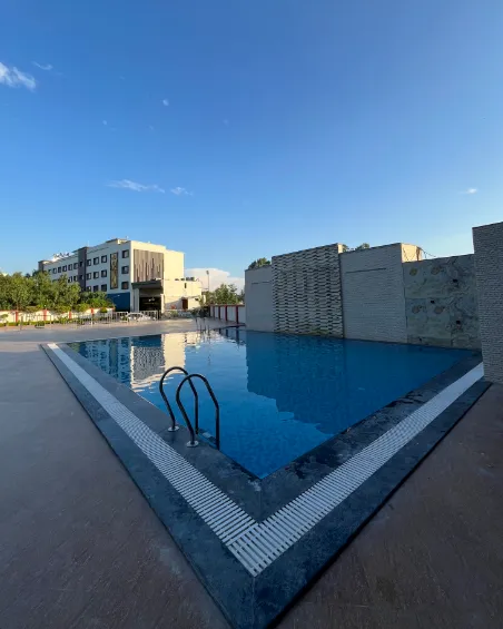 Swimming pool at Tulip Inn Shravasti with open deck and poolside area