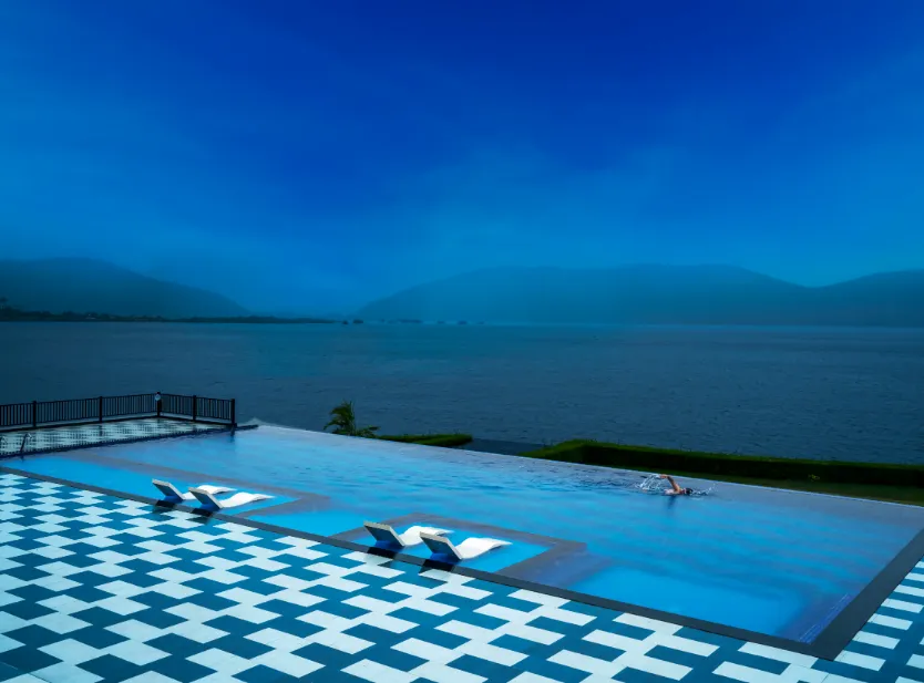Swimming pool at Zana Lake Resort Udaipur with pool deck and surrounding seating