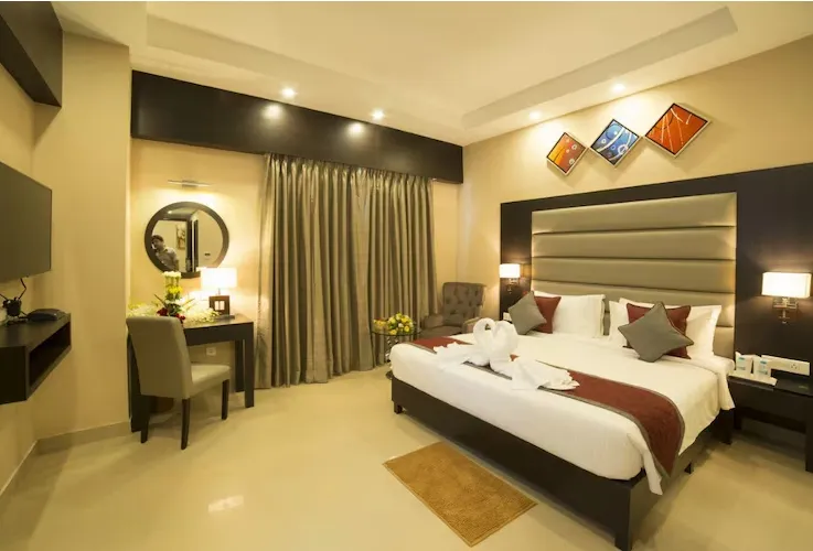 Deluxe room at Golden Tulip, Kolkata featuring spacious layout and work area