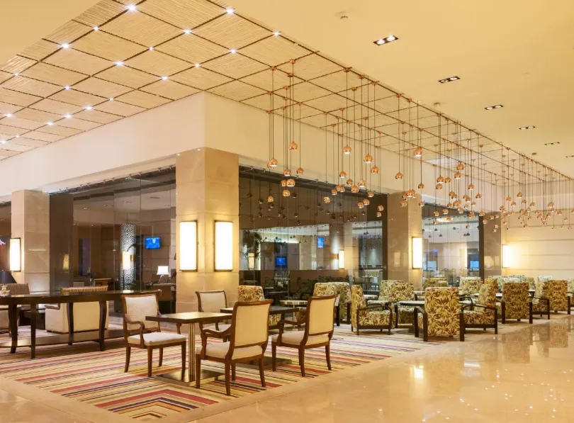 Restaurant at Balaji Sarovar Premiere Solapur with arranged dining tables