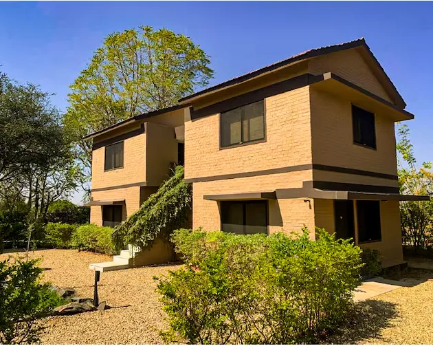 Deluxe Cottage with Garden View and Twin Bed at Clarks Safari Pushkar showing twin bedding and outdoor greenery