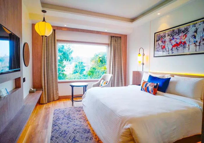 Deluxe room at Ishaan Sarovar Portico Deoghar featuring bed and interior lighting