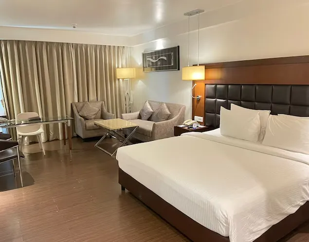 Deluxe room at Paradigm Sarovar Portico Kakinada with bed and soft lighting