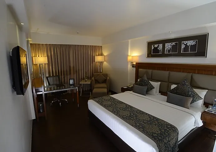 Superior room at Paradigm Sarovar Portico Kakinada with neatly made bed