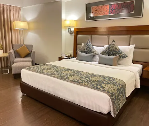 Superior room at Paradigm Sarovar Portico Kakinada with neatly made bed