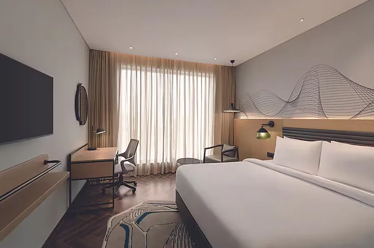 Deluxe room at Ramada Encore By Wyndham Bhiwadi featuring king bed and clean interior design