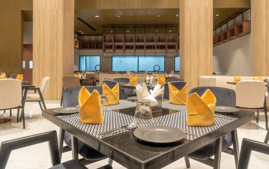 Dining area at Ramada Encore By Wyndham Bhiwadi with arranged tables and chairs