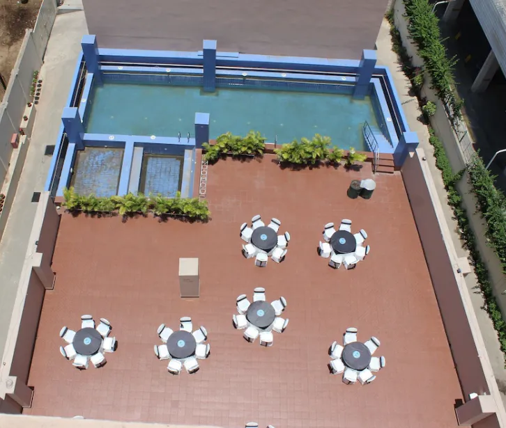 Outdoor pool area at Ramada by Wyndham Jamshedpur with clear water and deck chairs