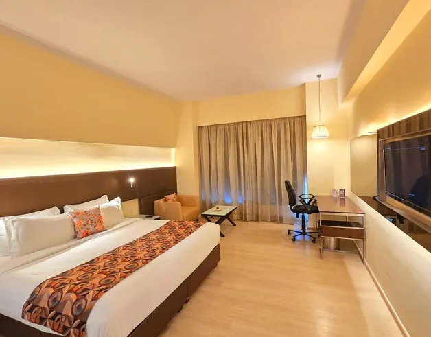 Executive room at Regenta Central Grand Exotica Pune with work desk and upholstered headboard