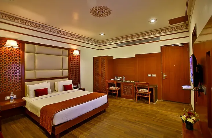 Premium room at Regenta Resort Vanya Mahal Ranthambore showing bed and seating area