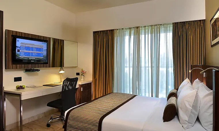 Deluxe room at Residency Sarovar Portico Goregaon Mumbai featuring modern decor and workspace