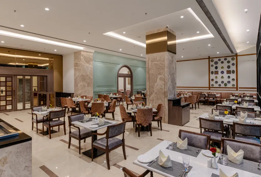 Restaurant at Sarovar Portico Ajmer with arranged dining tables and interior setting