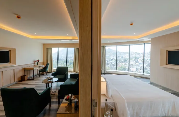 Suite at Sarovar Portico Ajmer showing cushioned seating and bed