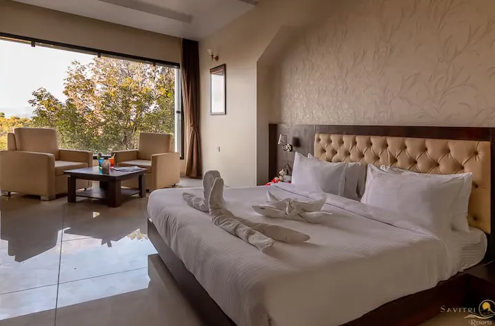 Deluxe room at Savitri Resorts Pushkar featuring bed and window lighting