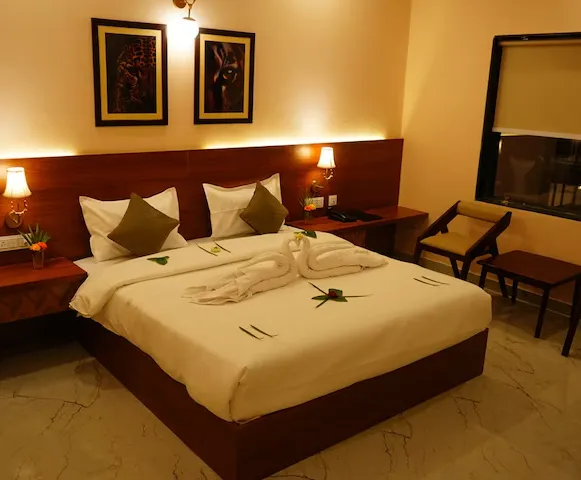 Super Deluxe room at Sundervan Vilas Ranthambore showing bed, seating, and lighting
