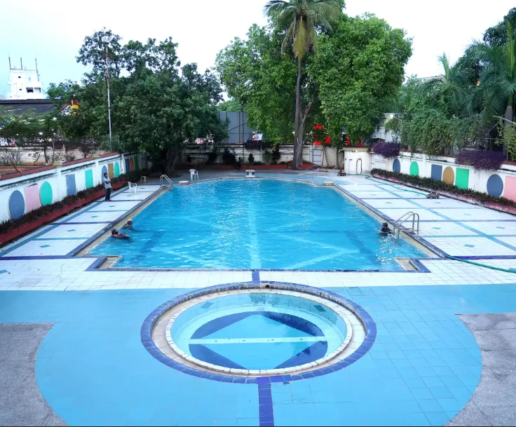 Outdoor swimming pool at The Fern Residency Kakinada with deck chairs