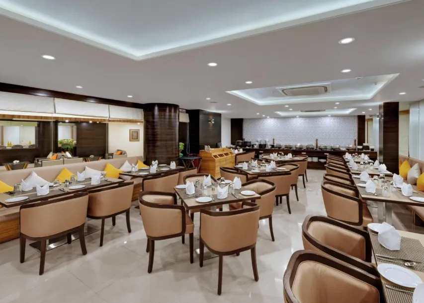 Dining area at The Fern Residency, MIDC, Pune with arranged tables and ceiling lighting