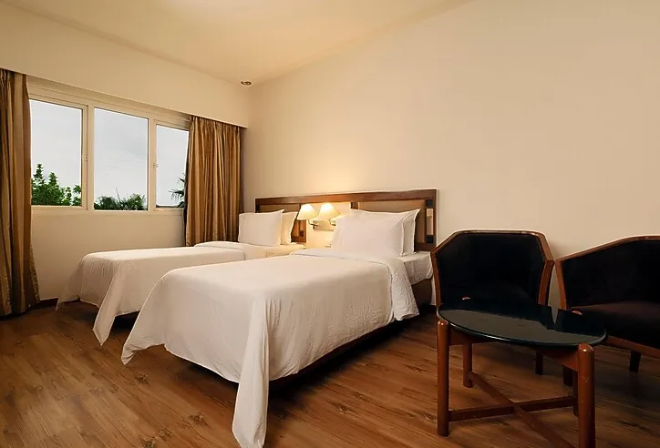 Standard room at The Residency Karur with double bed, work desk, and neutral décor
