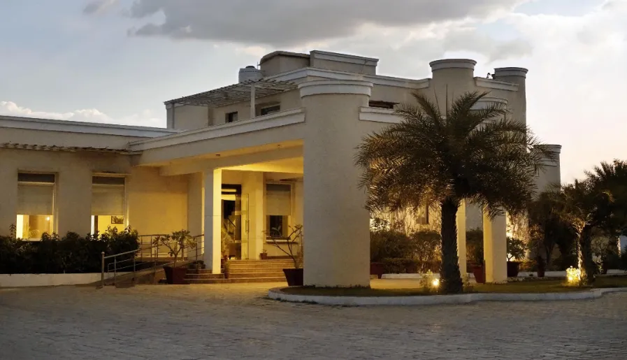 Entrance view of TreeHouse Sunrise Resort & Caravan Park Neemrana with driveway and building