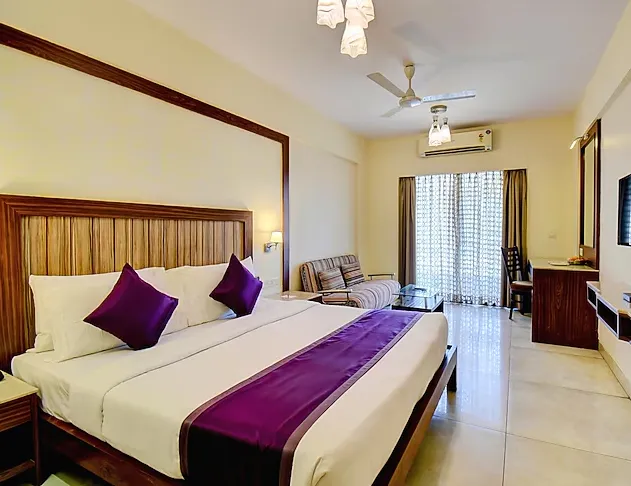 Deluxe king room at VITS Lonavala with large bed and soft lighting