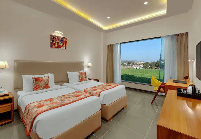 Executive room at Viola Beacon Resort Lonavala with bed and workspace area