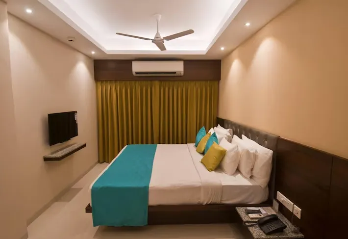 Suite room with king bed and separate seating area at Calangute Towers - AM Hotel Kollection Goa