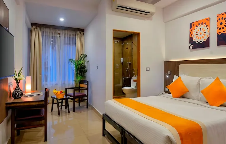 Superior room setup at TreeHouse Neptune Panaji Goa with modern bed and side lamps
